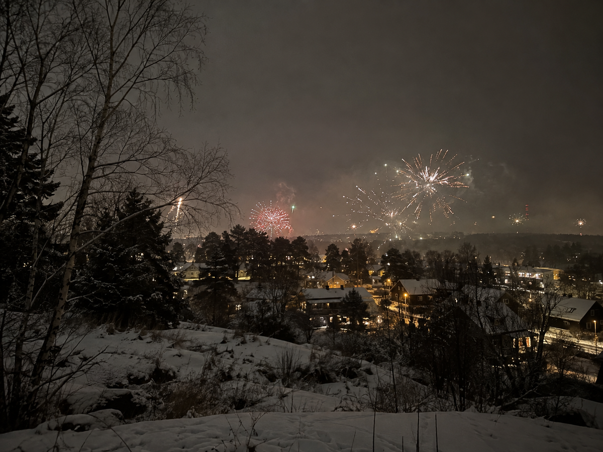 Fyrverkerier över ett bostadsområde en vinternatt vid nyår